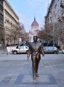 Budapest, Hungary - March 28, 2018: Statue of the former U.S. President Ronald Reagan on the background of Hungarian Parliament Building. Statue by sculptor Istvan Mate was unveiled on June 29, 2011.