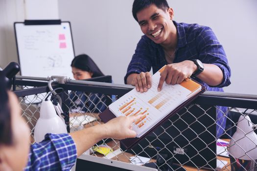 Manager holds financial report, shows rising stats and growing graphs to colleague, satisfied with great development rate, successful strategy, business growth