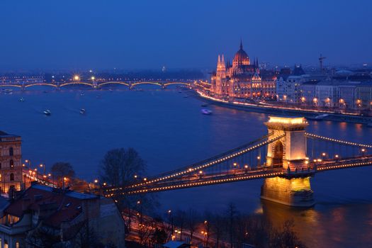 Budapest city night scene. View at Chain bridge, river Danube and famous building of Parliament. Budapest city is capital of Hungary.