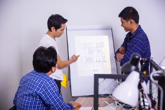 Team of architects who work on new projects and search for information from mobile.
Picture of architects working together in office