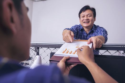 Manager holds financial report, shows rising stats and growing graphs to colleague, satisfied with great development rate, successful strategy, business growth