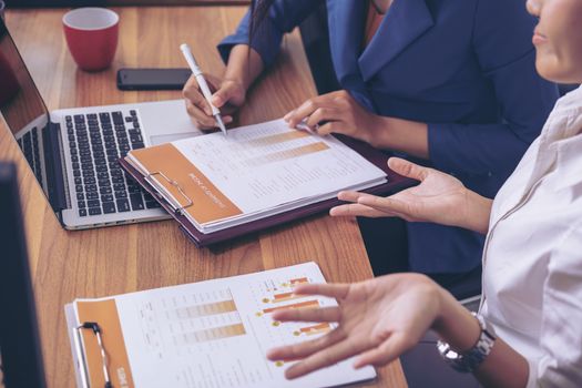 Businessman giving presentation on paper charts to colleagues in office. Business meeting time. Idea presentation, analyze plans.
