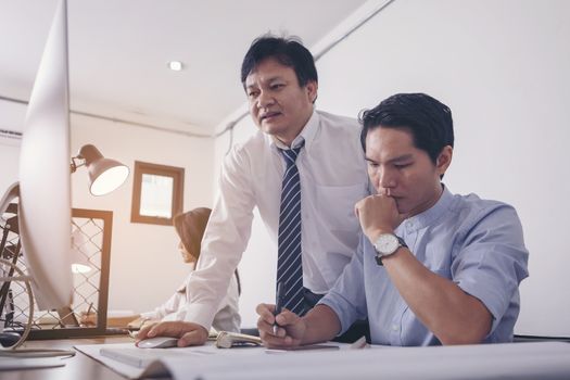 Businessman giving presentation on  computer screen to colleagues in office. Business meeting time. Idea presentation, analyze plans.