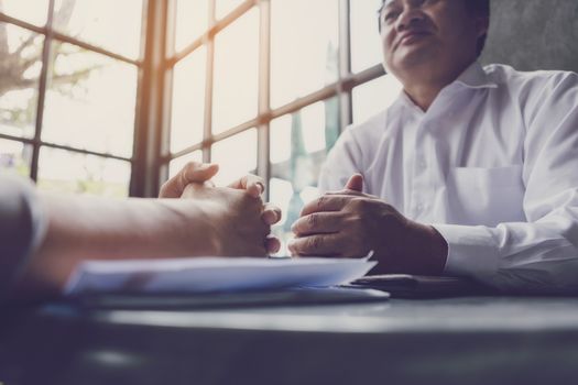 Interview or dialogue between businessman. Negotiation of two businessman with clasped hands in office.