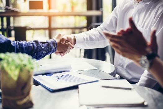 Businessmen negotiate in a coffee shop. Hold hands and greet before the business talks comfortably.