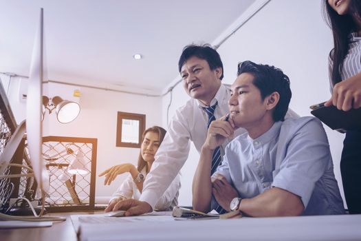 Businessman giving presentation on  computer screen to colleagues in office. Business meeting time. Idea presentation, analyze plans.