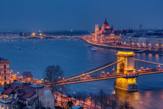 Budapest city night scene. View at Chain bridge, river Danube and famous building of Parliament. Budapest city is capital of Hungary.