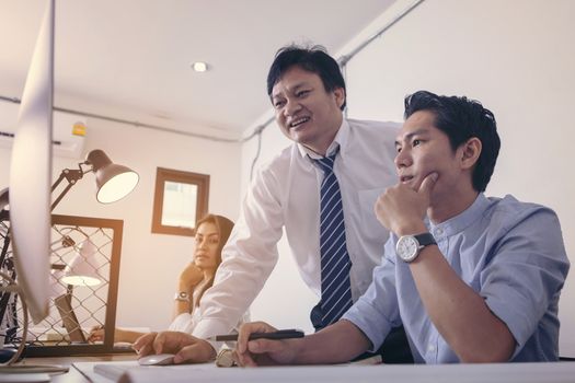 Businessman giving presentation on  computer screen to colleagues in office. Business meeting time. Idea presentation, analyze plans.