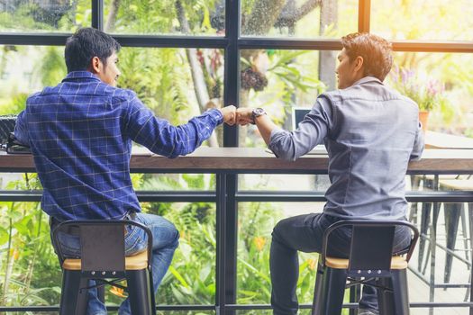 Businessmen negotiate in a coffee shop. Hold hands and greet before the business talks comfortably.