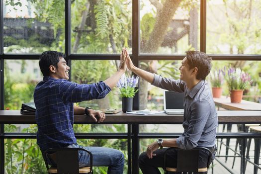 Businessmen negotiate in a coffee shop. Hold hands and greet before the business talks comfortably.