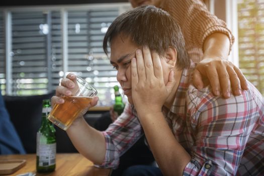 alcoholic businessman is comforted by a colleague in a nightclub after work.  stressed, consolation