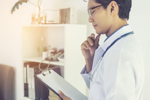 The doctor reads patient information for treatment.