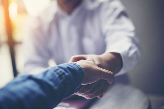 Businessmen negotiate in a coffee shop. Hold hands and greet before the business talks comfortably