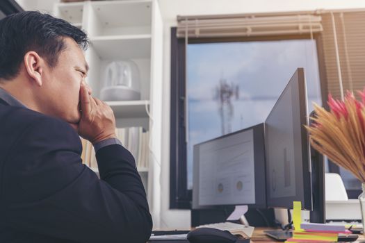 Stressed businessman having severe headache, holding painkiller remedy pill. Stress job