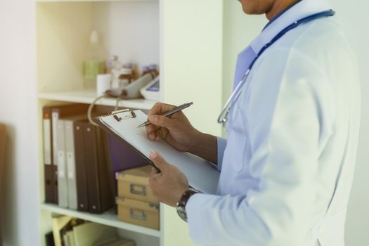 The doctor reads patient information for treatment.