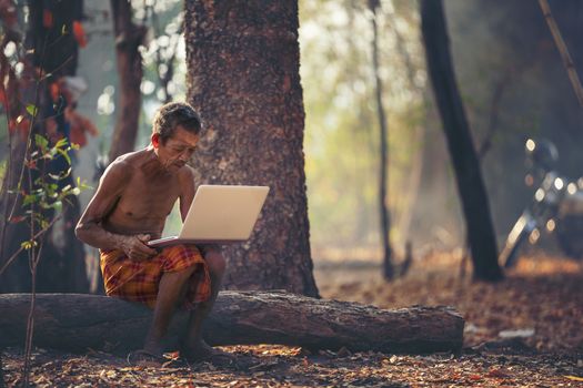 Farmers wearing a loincloth to find information on planting from the computer. modern technology application in agricultural growing activity