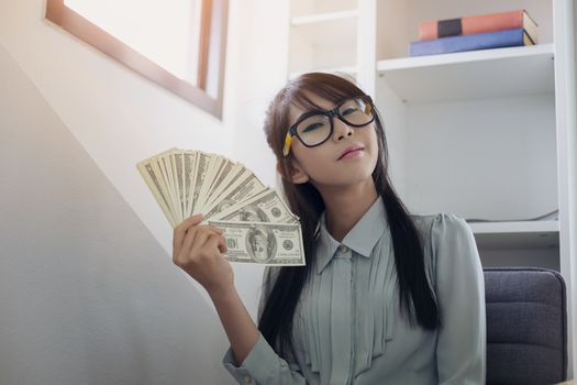 Successful business women are counting money and throwing a dollar at work happily.