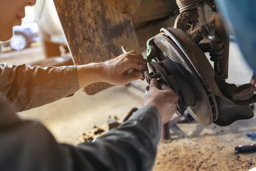 The car repairer is checking the car for maintenance. People who work on cars in the garage do their own homework. Check / inspect the engine for trouble; Diagnose and fix / fix preventative maintenance issues.