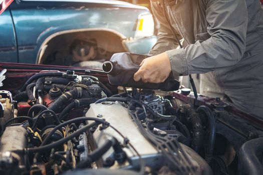 The car repairer is checking the car for maintenance. People who work on cars in the garage do their own homework. Check / inspect the engine for trouble; Diagnose and fix / fix preventative maintenance issues.