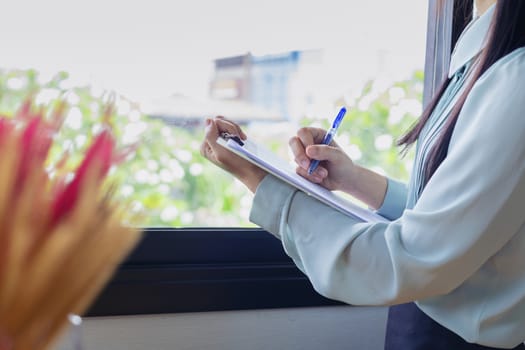 Beautiful business woman looking for documents she holds in her arms while working at her office and smile happy with her work.