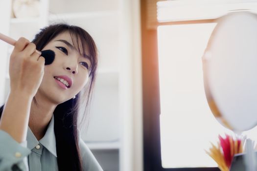 Young businesswoman made up at work, a beautiful young woman doing makeup before work starts to brighten up and add to her confidence.