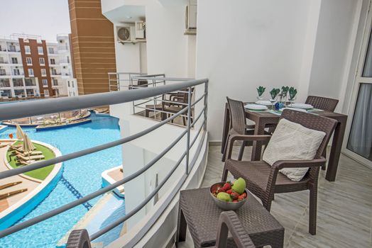 Terrace furniture of a luxury apartment in tropical resort with plastic furniture and pool view