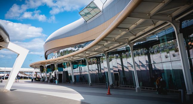 Faro, Portugal - May 3, 2018: Exterior view of Faro International Airport where passengers are walking with their suitcases on a spring day