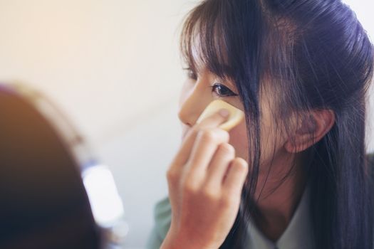 Young businesswoman made up at work, a beautiful young woman doing makeup before work starts to brighten up and add to her confidence.