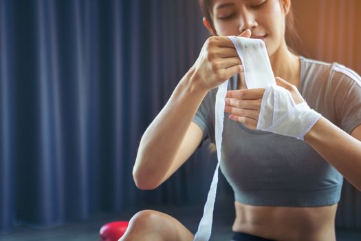 Beautiful women who love health. Two of her hands with white boxing bandage hand wrap to prepare for exercise by boxing. Active girl fight