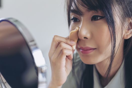 Young businesswoman made up at work, a beautiful young woman doing makeup before work starts to brighten up and add to her confidence.