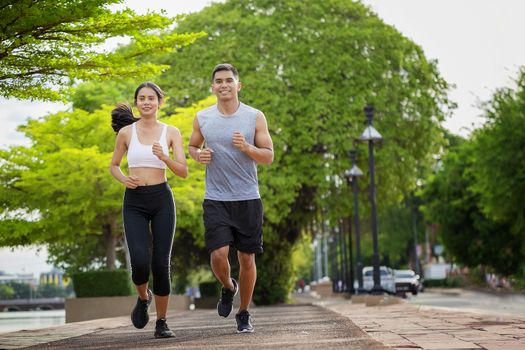 Couples who take care of their health by exercising happily in the city. Health care concept