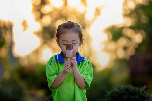 portrait of happy girl eats ice cream in a public garden.