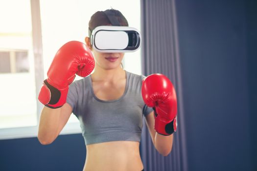 Beautiful woman wearing augmented reality standing in a boxing posture, playing action game simulation, mobile app, female player fighting with fist in a VR headset, technology, high-tech, game con