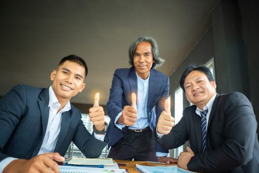 The three businessmen who thumbs up indicate the success of their business operations. Teamwork concept for development and success