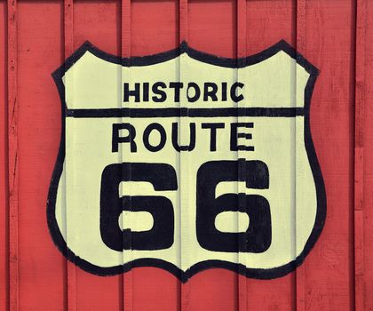 Historic U.S. old Route 66 sign with wooden background.