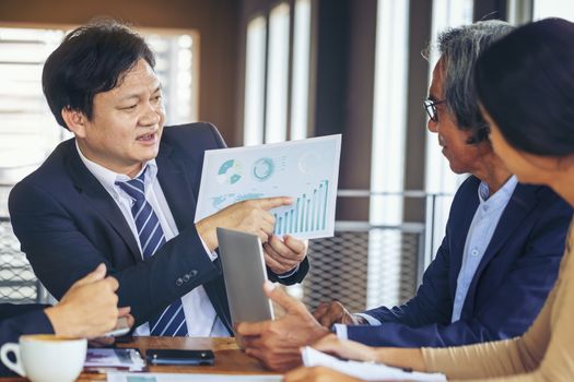 Image of business people hands working with papers at meeting. Businessman holding pens and holding graph paper are meeting to plan sales to meet targets set in next year.