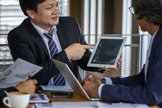 Image of business people hands working with papers at meeting. Businessman holding pens and holding graph paper are meeting to plan sales to meet targets set in next year.