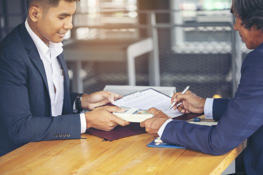 Image of business people hands working with papers at meeting. Businessman holding pens and holding graph paper are meeting to plan sales to meet targets set in next year.