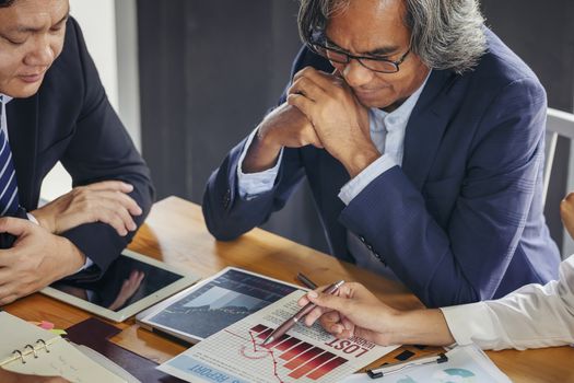 Image of business people hands working with papers at meeting. Businessman holding pens and holding graph paper are meeting to plan sales to meet targets set in next year.