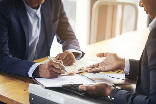 Image of business people hands working with papers at meeting. Businessman holding pens and holding graph paper are meeting to plan sales to meet targets set in next year.