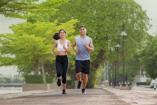 Couples who take care of their health by exercising happily in the city. Health care concept