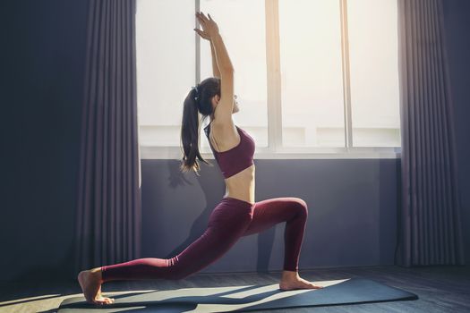 Young sporty woman practicing yoga, doing Purvottanasana exercise, working out, wearing sportswear, Red pants and top, indoor full length