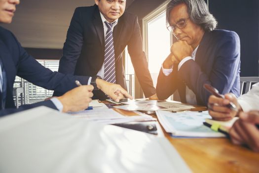 Image of business people hands working with papers at meeting. Businessman holding pens and holding graph paper are meeting to plan sales to meet targets set in next year.