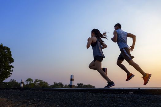 Running at sunrise couple exercising for marathon and workout 
fitness, sport, people and lifestyle concept - Happy couples exercising with outdoor running