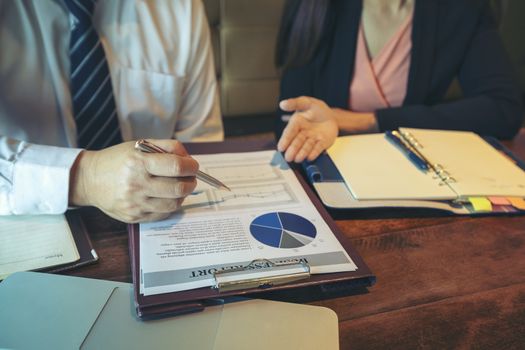 Successful businessman boss presenting new project to employees, businessman giving presentation to clients in meeting room, team leader reporting about work explaining result on flipchart. 