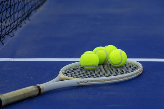 Close-up tennis racket and ball placed on on the blue field