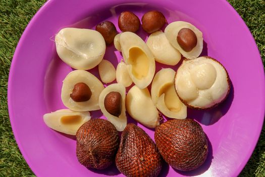 Close up of peeled, cuted and whole pieces of Snake fruit with seed. Top view of healthy fruit. Salak pondoh is one of the salak cultivars that mostly grows in Bali. Macro photo of Sweet Salacca.