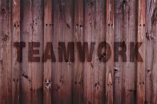 Teamwork word engraved on wood expressing teamwork concept.
