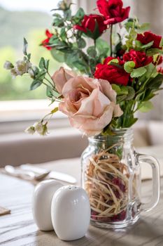 Table setting with rose in restaurant or cafe.