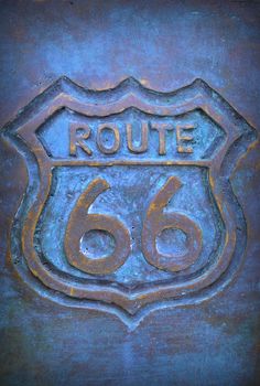 Old route 66 sign in bronze with blue color.